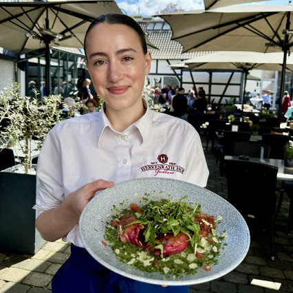 Serviererin mit Vorspeise im Hof